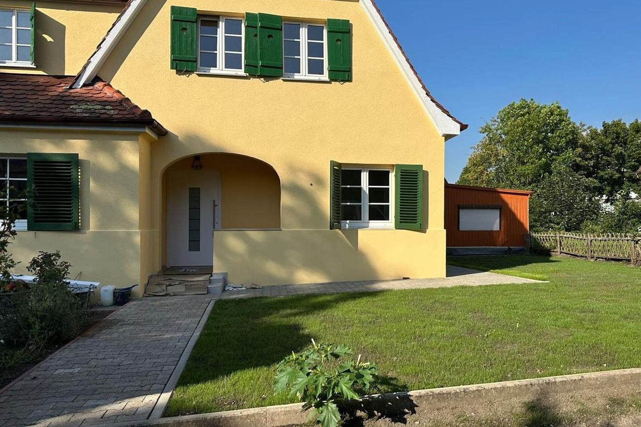 Dasselbe Haus nach der Sanierung durch Maai Bautechnik mit neuem Putz, fertigem Eingang und angelegtem Rasen