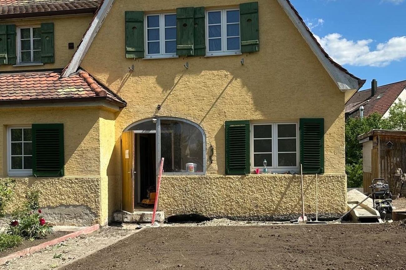 Hausfassade vor der Sanierung durch Maai Bautechnik, Eingang unverputzt und Vorgarten aufgegraben