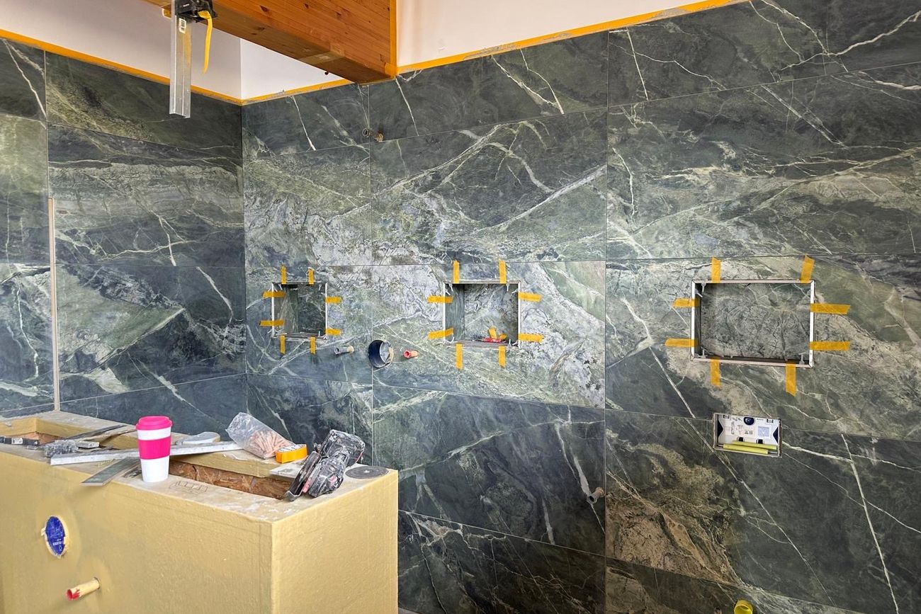 Großformatig gefliestes Badezimmer in Marmoroptik, ausgeführt von Maai Bautechnik