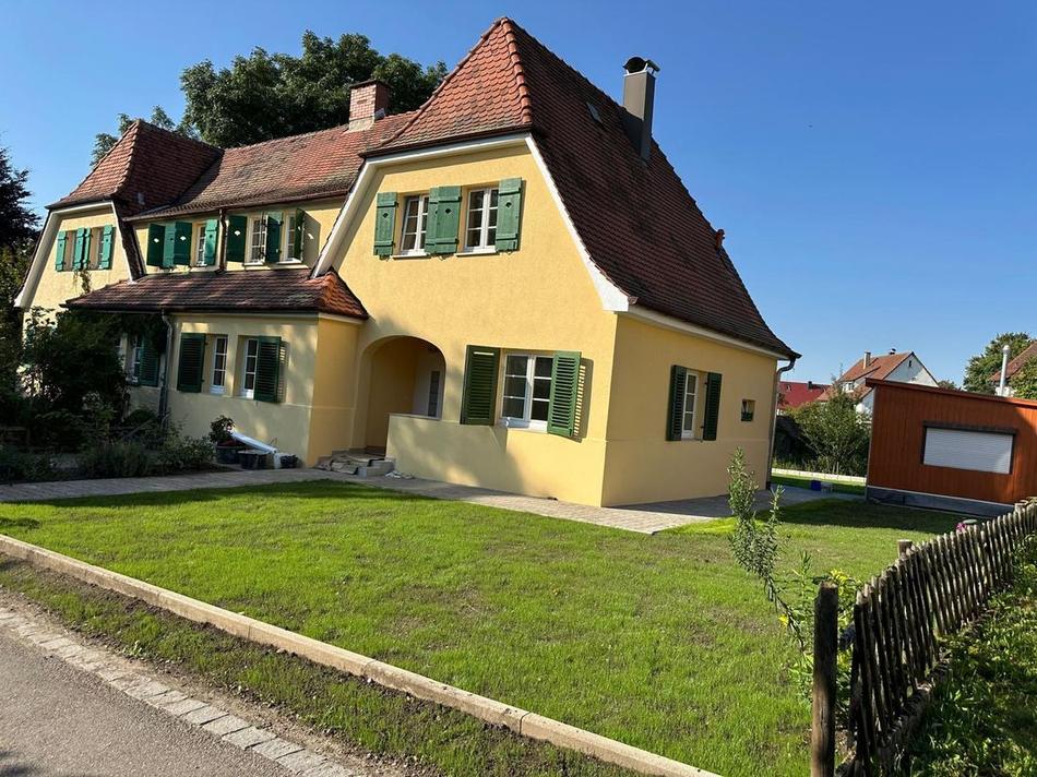 Saniertes Wohnhaus mit neuer Fassade und angelegtem Garten, ausgeführt von Maai Bautechnik